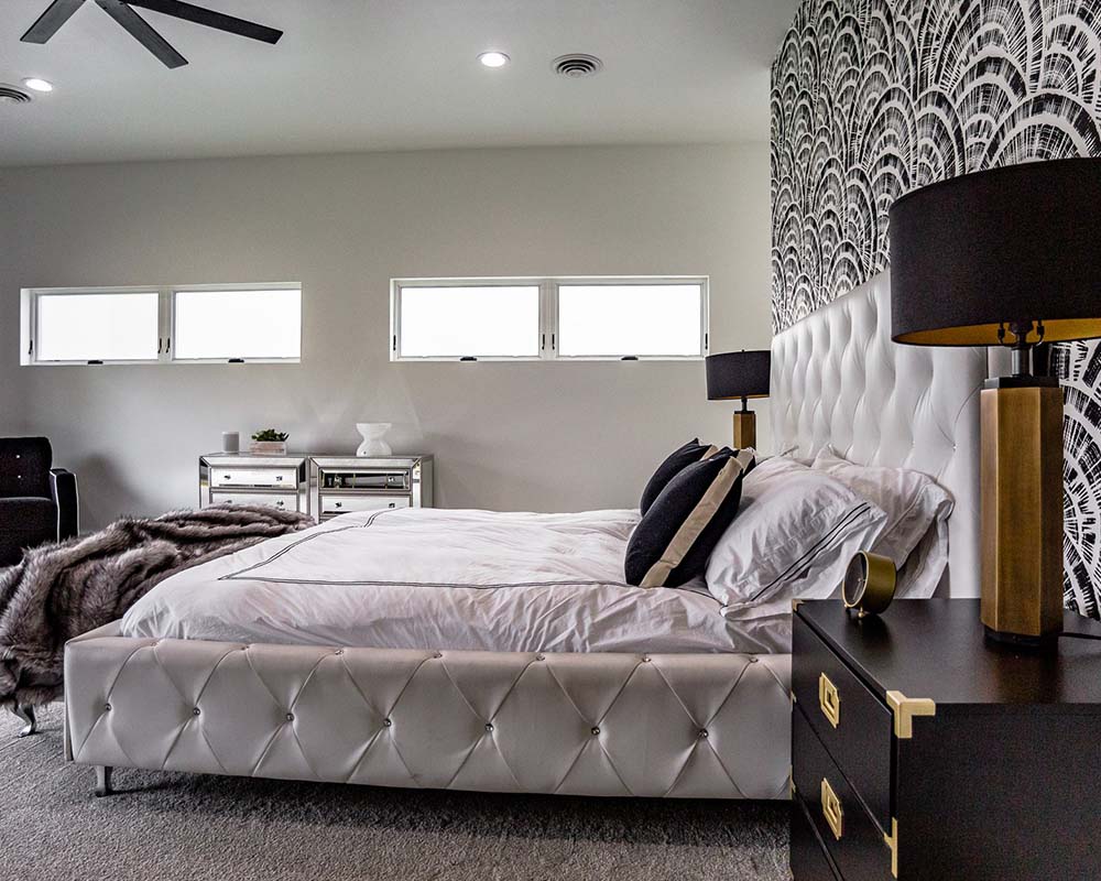 A nice modern bed with a unique black and white wallpaper