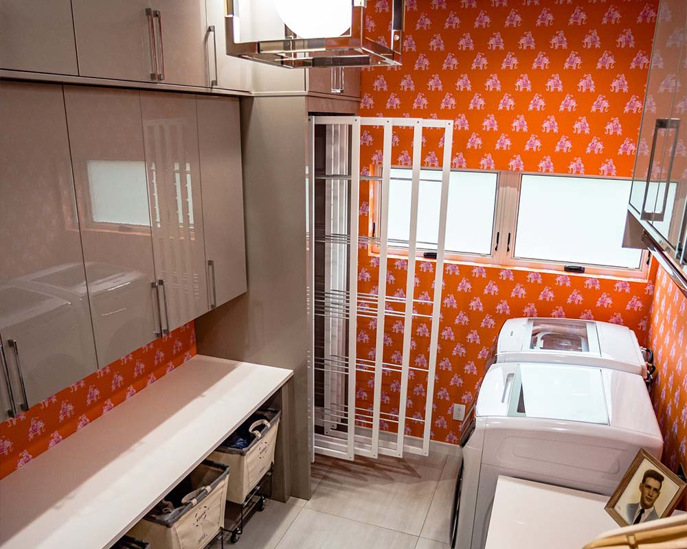A laundry room with bright orange wallpaper
