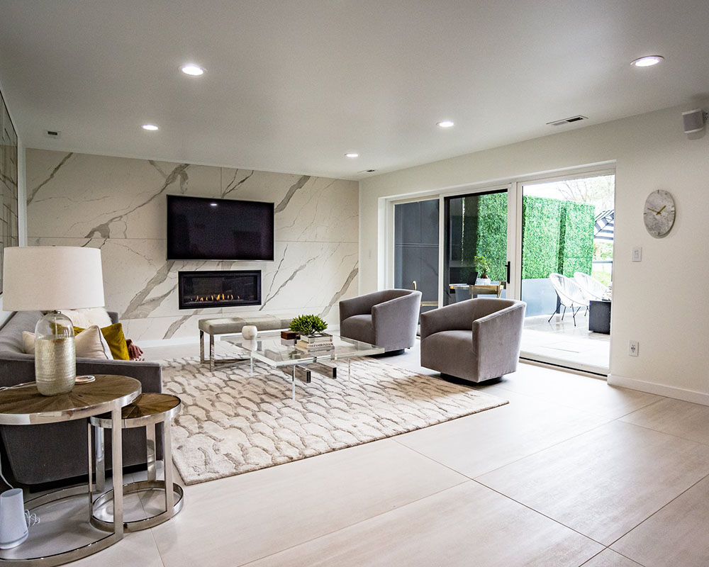 The updated living room with marble like walls and a nice white carpet