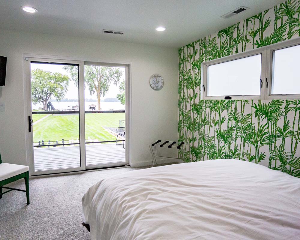 A bedroom with bright green bamboo wallpaper