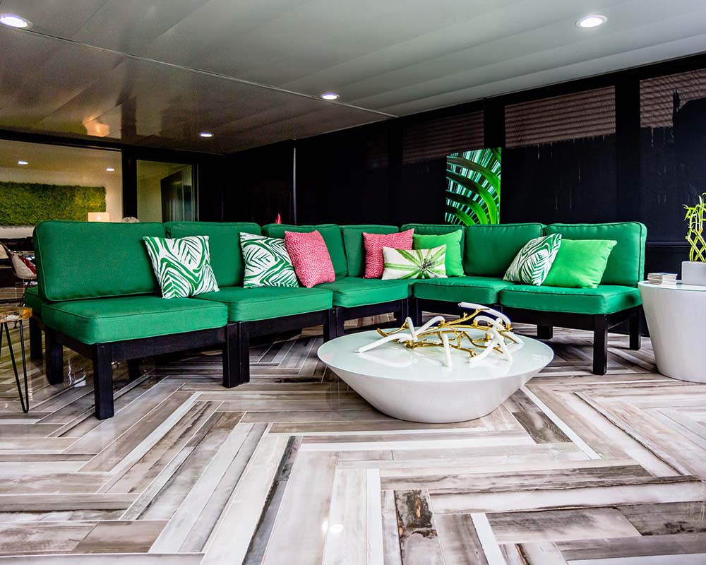 the updated screen porch with a bright green couch