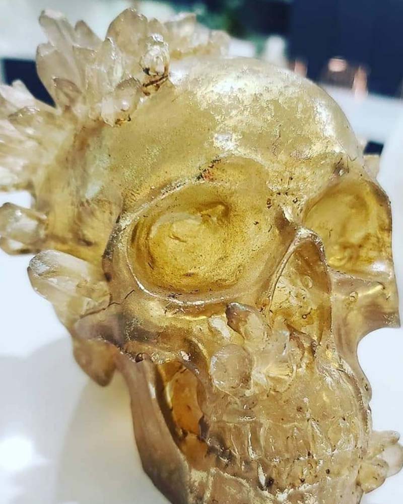 A gold skull with crystals all over it