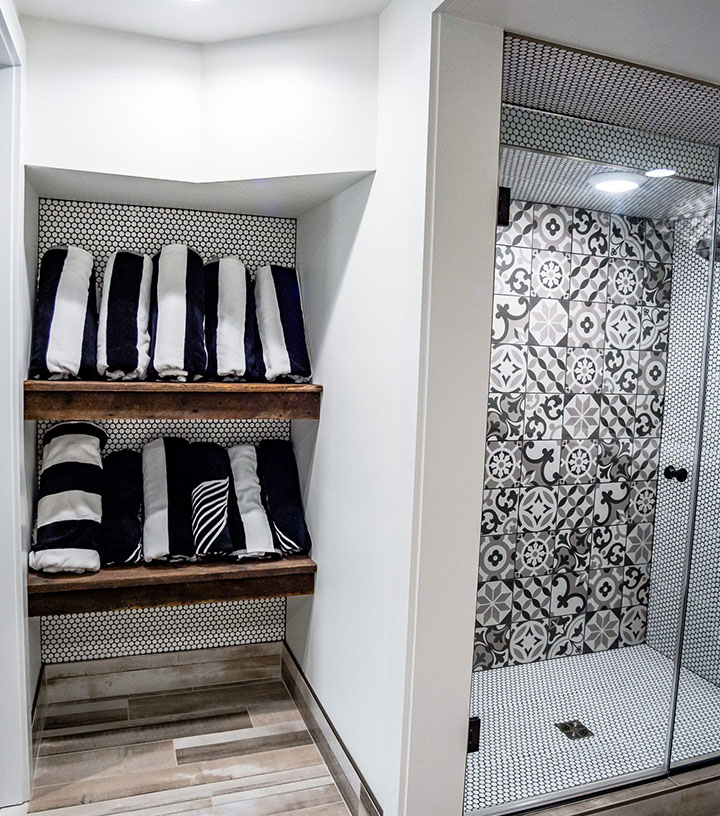 A bathroom shower with unique black and white tiles