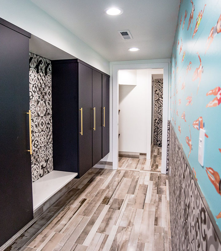 A bathroom with unique black and white tiles and blue wallpaper of swimming people