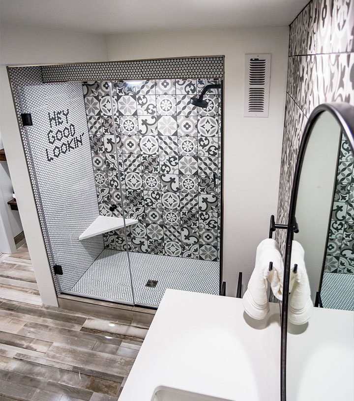 A bathroom shower with unique black and white tiles
