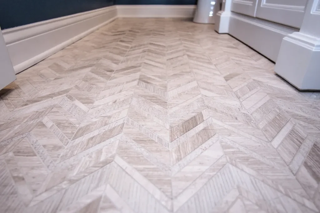Light herringbone tile flooring in modern bathroom interior