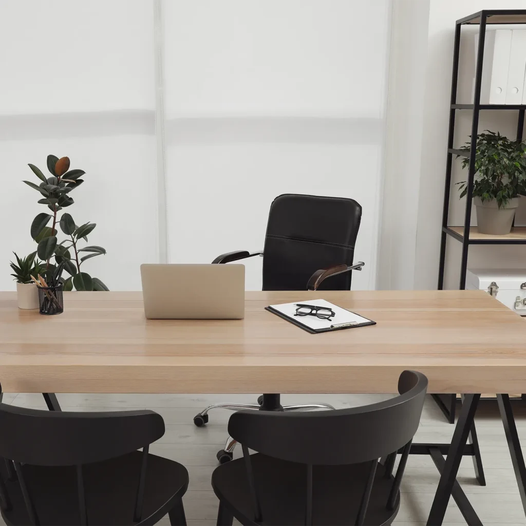 Modern home office with wooden desk, black chairs, and minimalist workspace decor