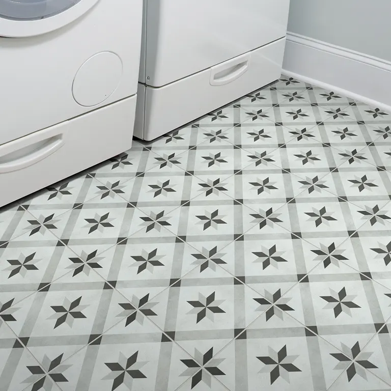 Gray and white patterned tile flooring in modern laundry room with washer and dryer